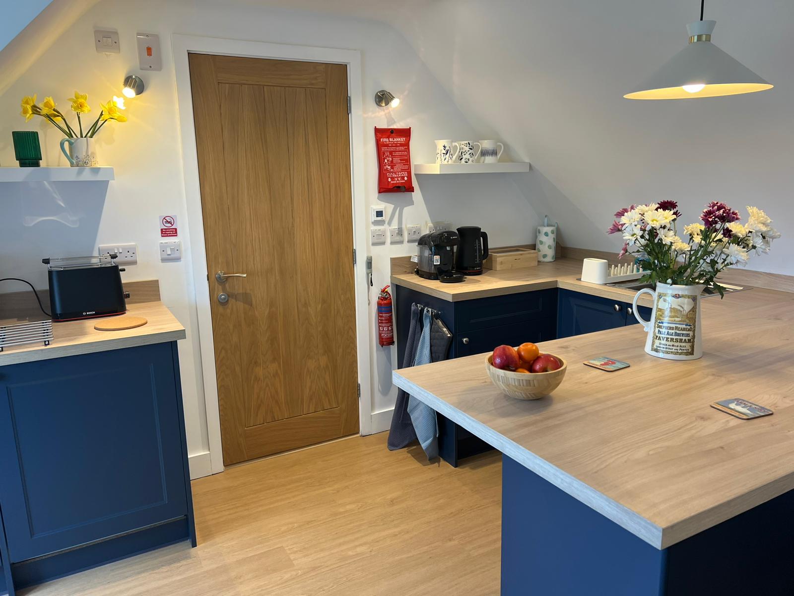 Navy blue fitted kitchen with oak worktops