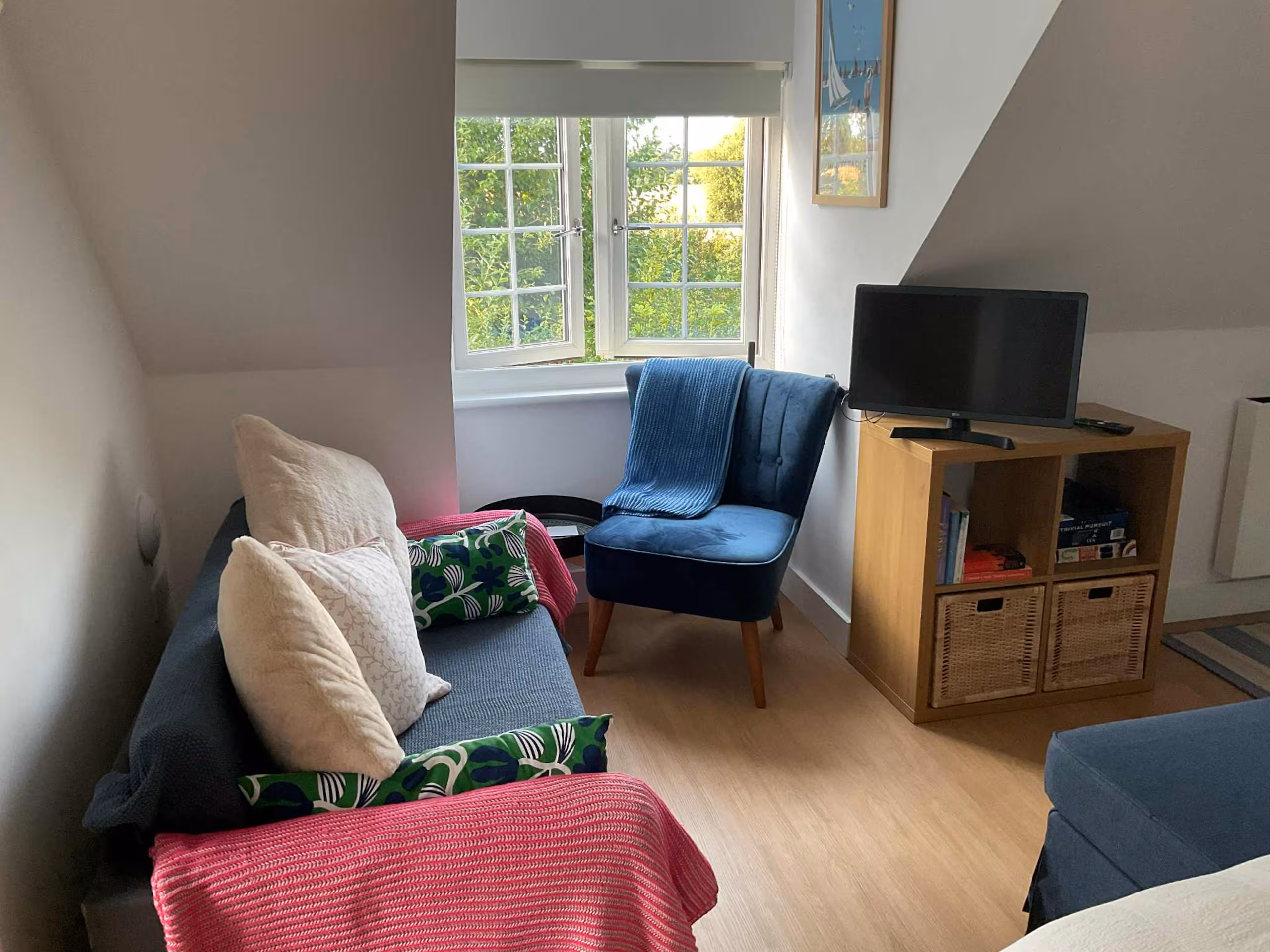 Cosy living room with sofa, blue velvet armchair and TV